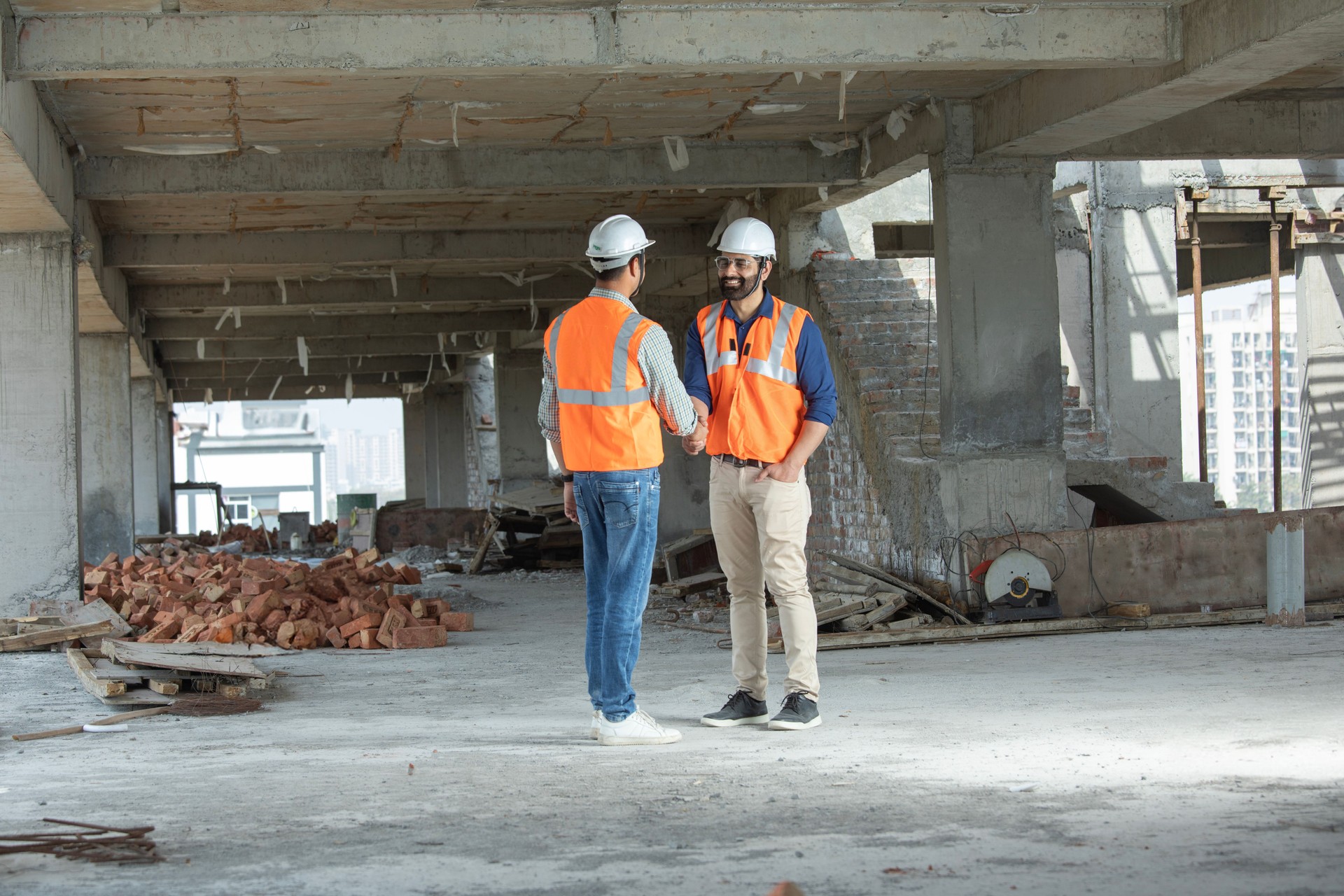 Male coworkers shaking hands at construction site